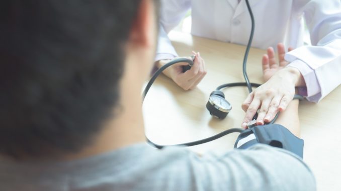 Doctor checking patient arterial blood pressure